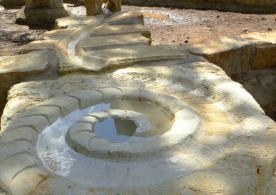 künstlerisch gestalteter Wasserspielplatz aus Naturstein mit Wasserspeier Wasserrinne und Wasserkaskade