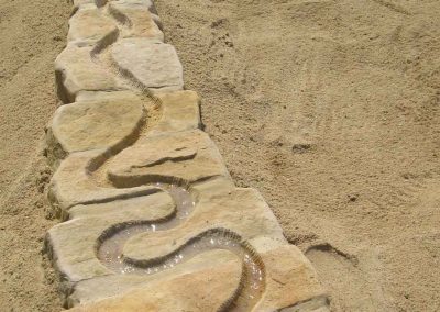 schlängelnde wasserrinne im Sandstein eingearbeitet zum Spielen und Matschen für Kindergärten