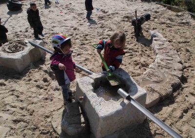 Kinder spielen in der neuen Wasserspielanlage der Kita Herne